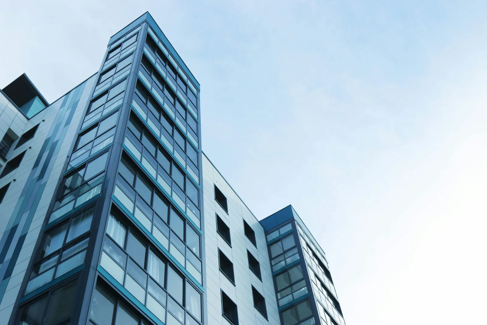 Office building with glass facade against a blue sky